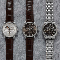 Certina DS 8 Moon Phase herreur med brun skive og brun læderrem, ved siden af andre ure fra samme serie