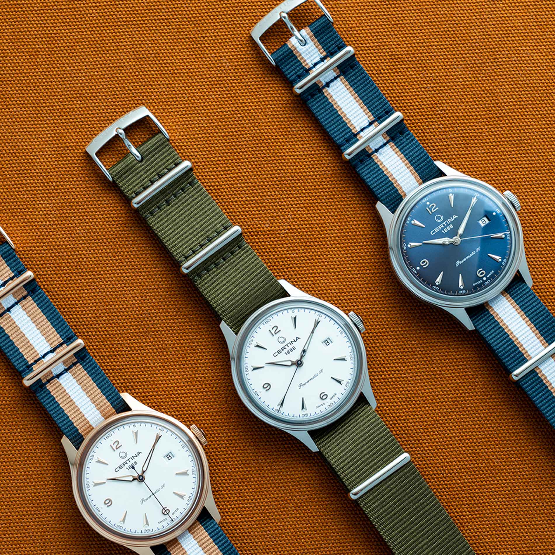 Certina DS Powermatic 80 herreur med grøn natorem og hvid skive, ved siden af andre ure fra samme serie