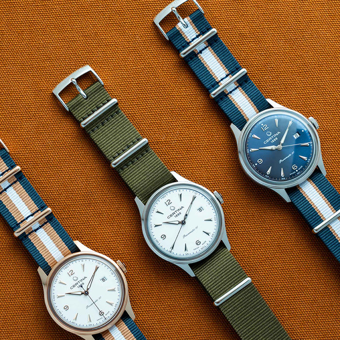 Certina DS Powermatic 80 herreur med grøn natorem og hvid skive, ved siden af andre ure fra samme serie