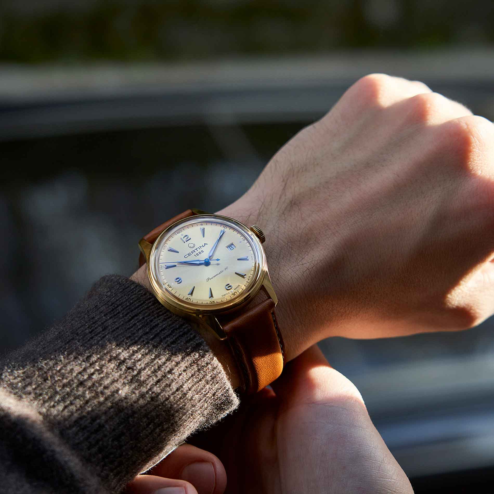 Certina DS Powermatic 80 herreur med guld skive og brun læderrem, på håndled