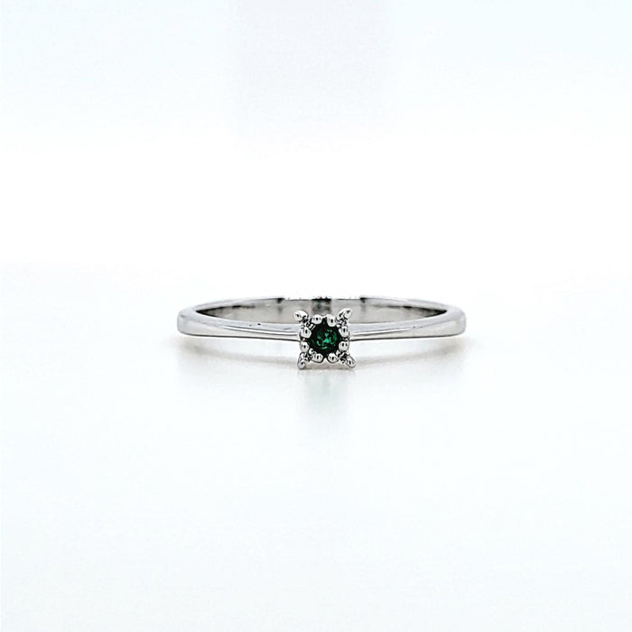 Ring i hvidguld med en grøn smaragd i midten og 4 diamanter omkring den, set forfra