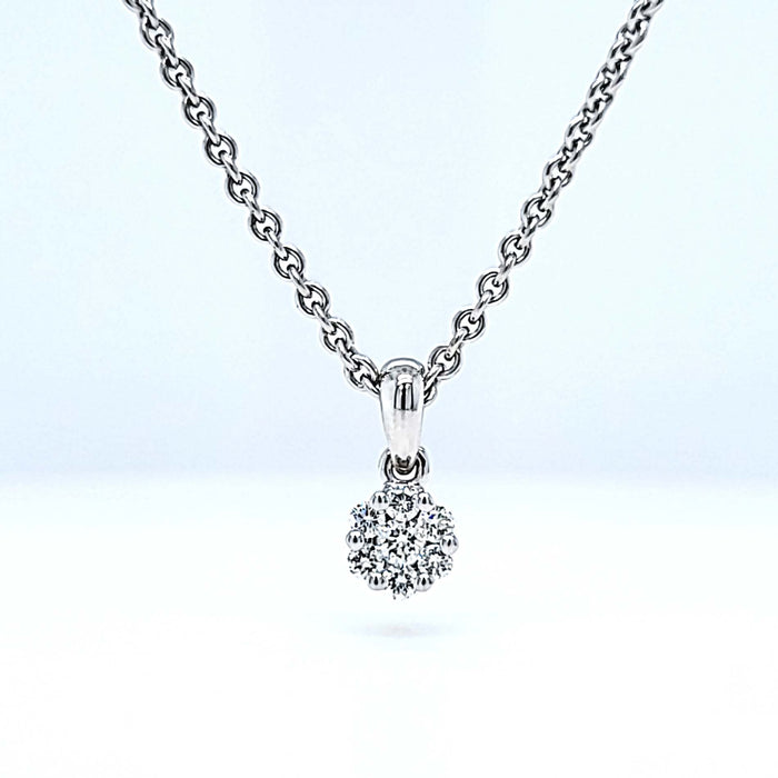 Vedhæng i hvidguld med 7 diamanter formet som en blomst, set på kæde