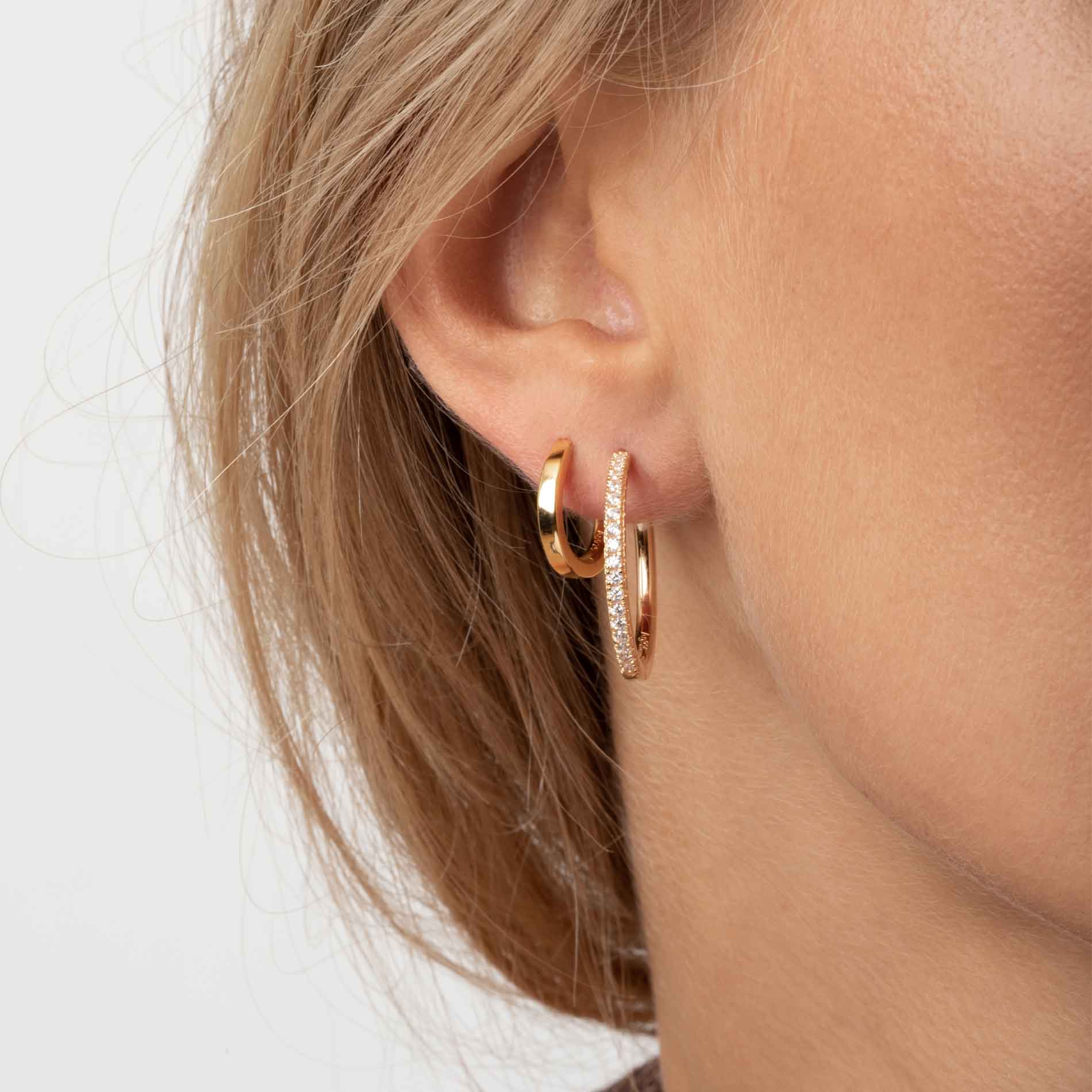 Sif Jakobs Ellera X-Grande øreringe i forgyldt sølv med hvide zirkonia, 24 mm. Set på model