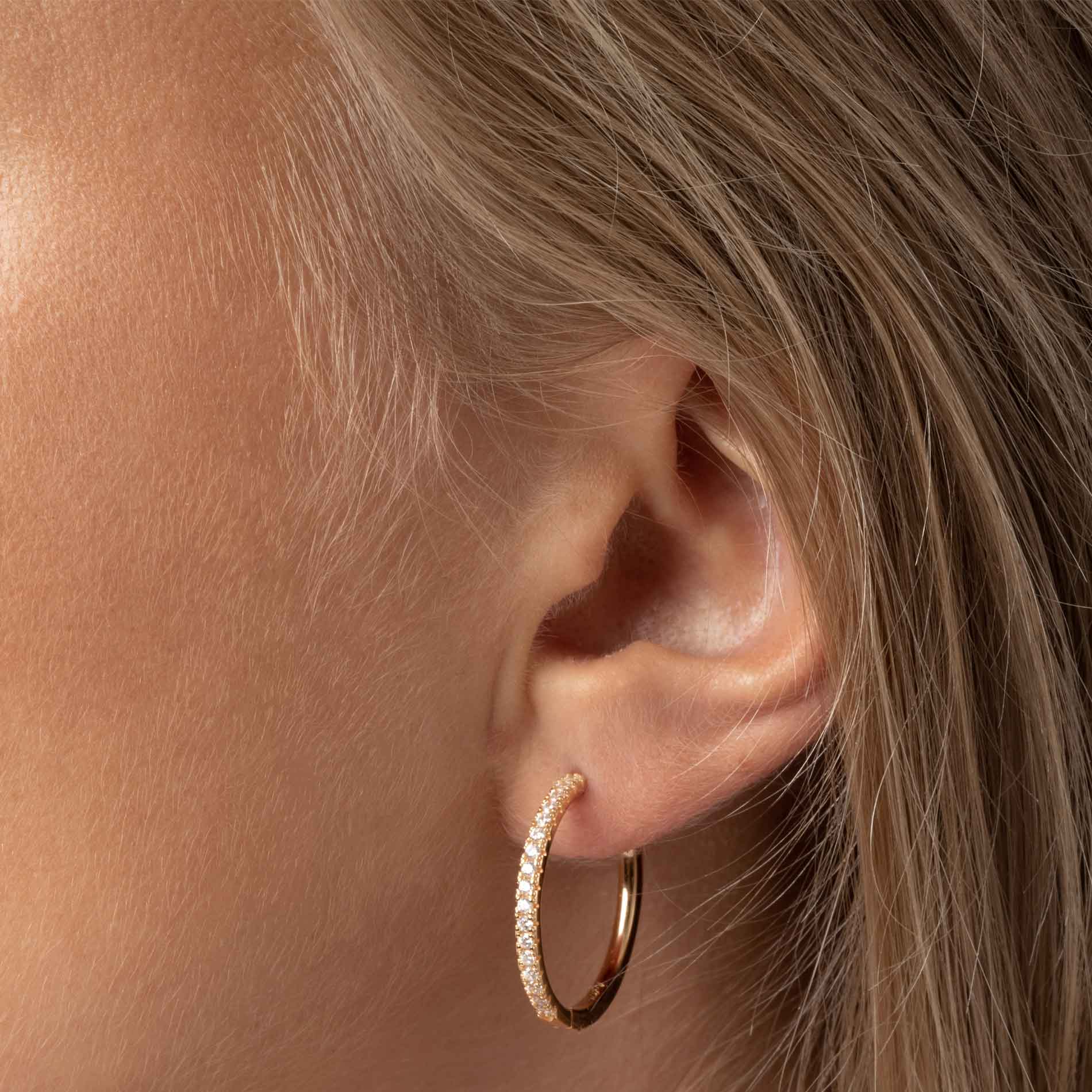 Sif Jakobs Ellera X-Grande øreringe i forgyldt sølv med hvide zirkonia, 24 mm. Set på model