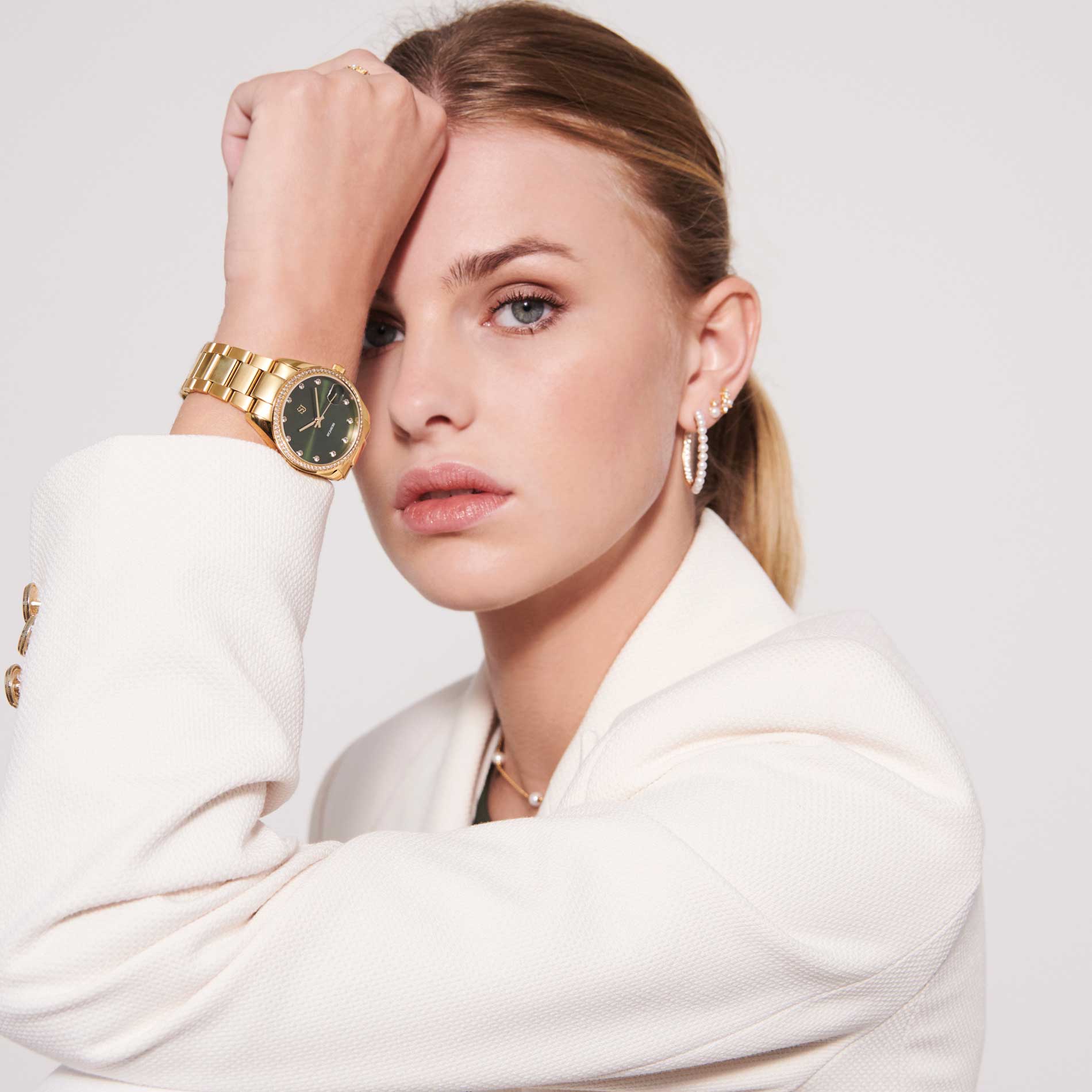 Sif Jakobs Aurora i guld tone med grøn skive og zirkonia sten rundt kransen, set på model