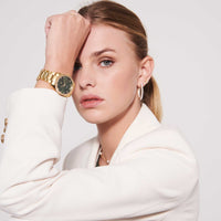 Sif Jakobs Aurora i guld tone med grøn skive og zirkonia sten rundt kransen, set på model