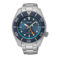 Seiko herreur i stål med blå urskive med orange GMT-viser og blå krans. Uret ses forfra.