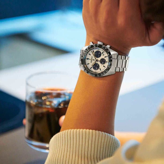 Seiko herreur i stål med hvid urskive med tre sorte chronographer. Uret ses på et håndled.