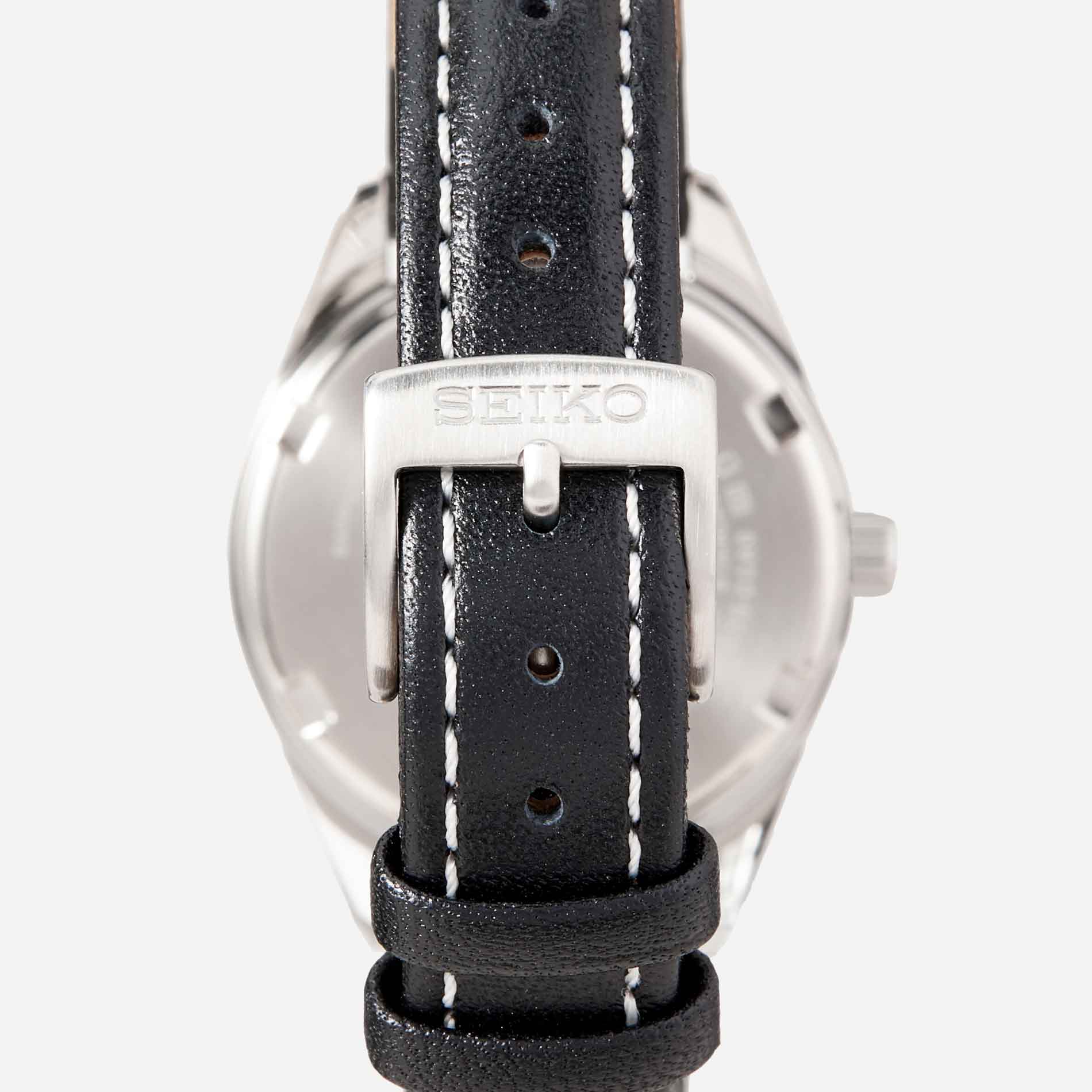 Seiko dameur i stål med sort læderrem. Uret ses bagfra.