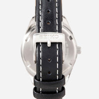 Seiko dameur i stål med sort læderrem. Uret ses bagfra.