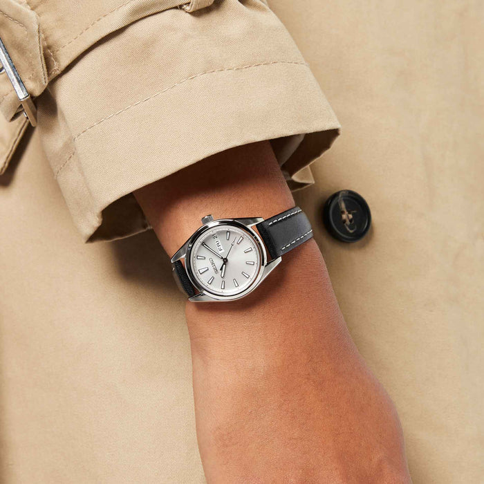 Seiko dameur i stål med sort læderrem. Uret ses på et håndled.