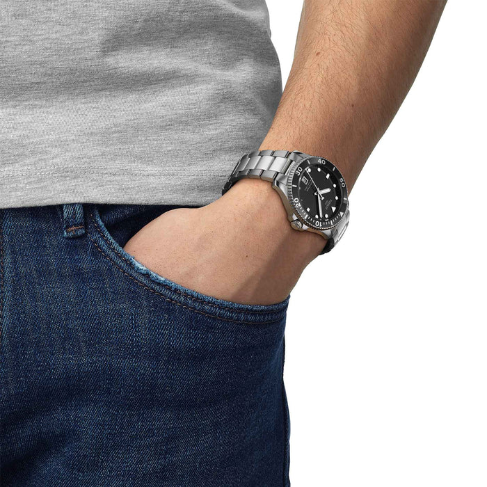 Klassisk dykkerur i stål med sort skive og krans, på håndled