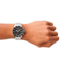 Emporio Armani Diver AR11360 herreur med en stål-urkasse og stållænke. Uret har en sort urskive og datovisning. Uret ses på håndledet af en mand.