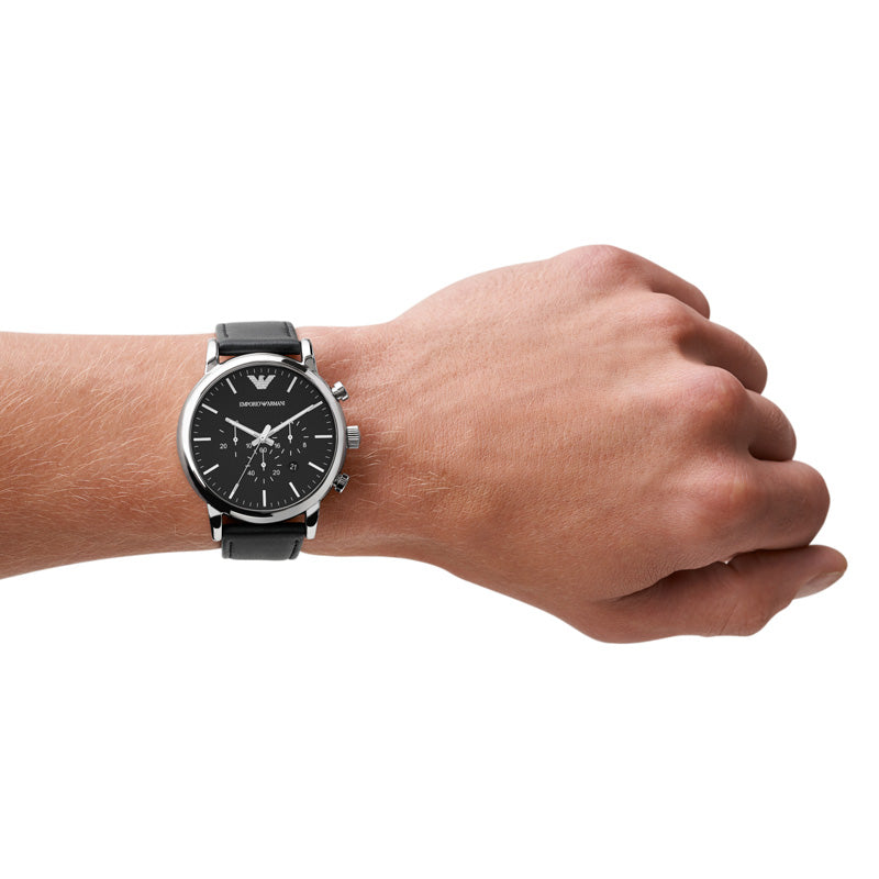Emporio Armani Luigi AR1828 herreur i sort med læderrem. Uret ses på håndledet af en mand.