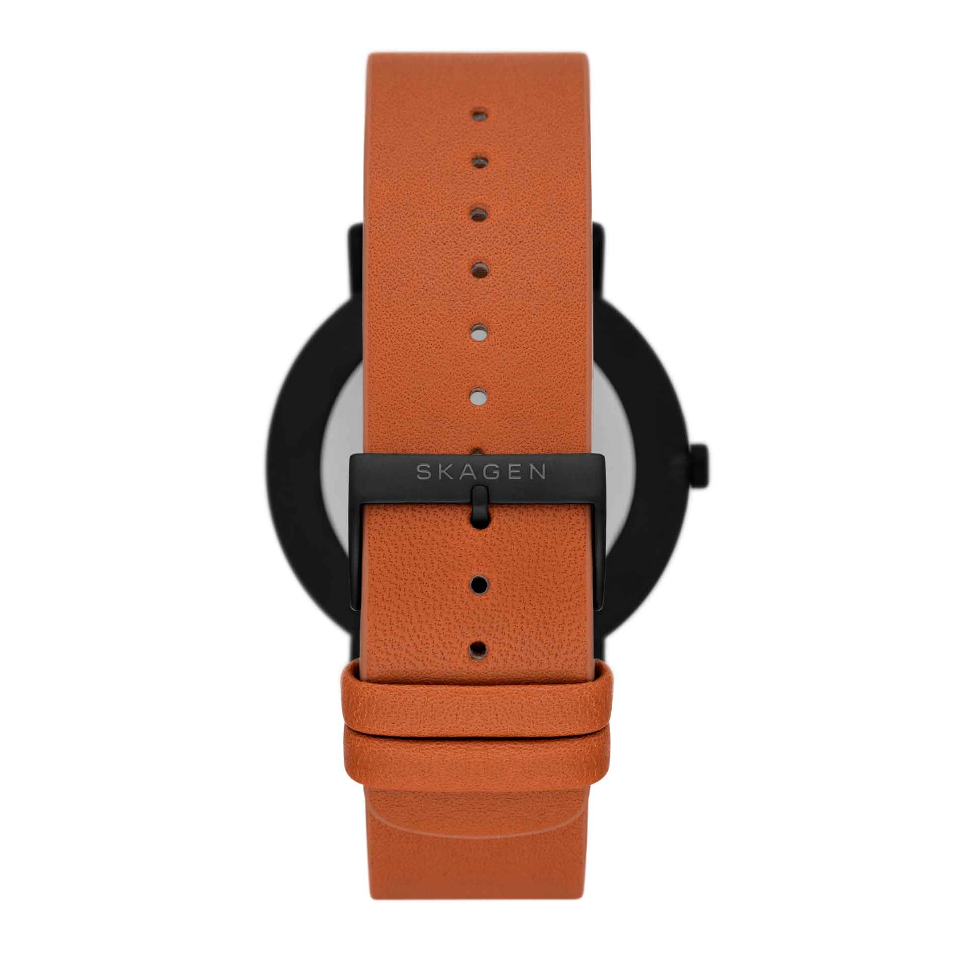 Skagen ur med sort stålurkasse, hvid skive og brun læderrem. Uret har arabertal på skiven. Uret ses bagfra.