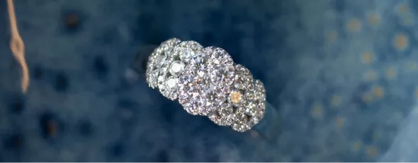 Diamantring set oppefra med blå baggrund.