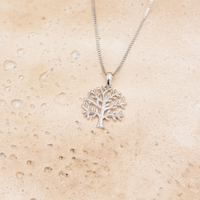 Leaf halskæde i sterling sølv med træmotiv vist på lys stenoverflade