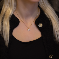 Ocean vedhæng i guld båret på hals
