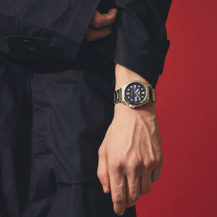 Seiko herreur i stål med blå urskive. Uret ses på et håndled.