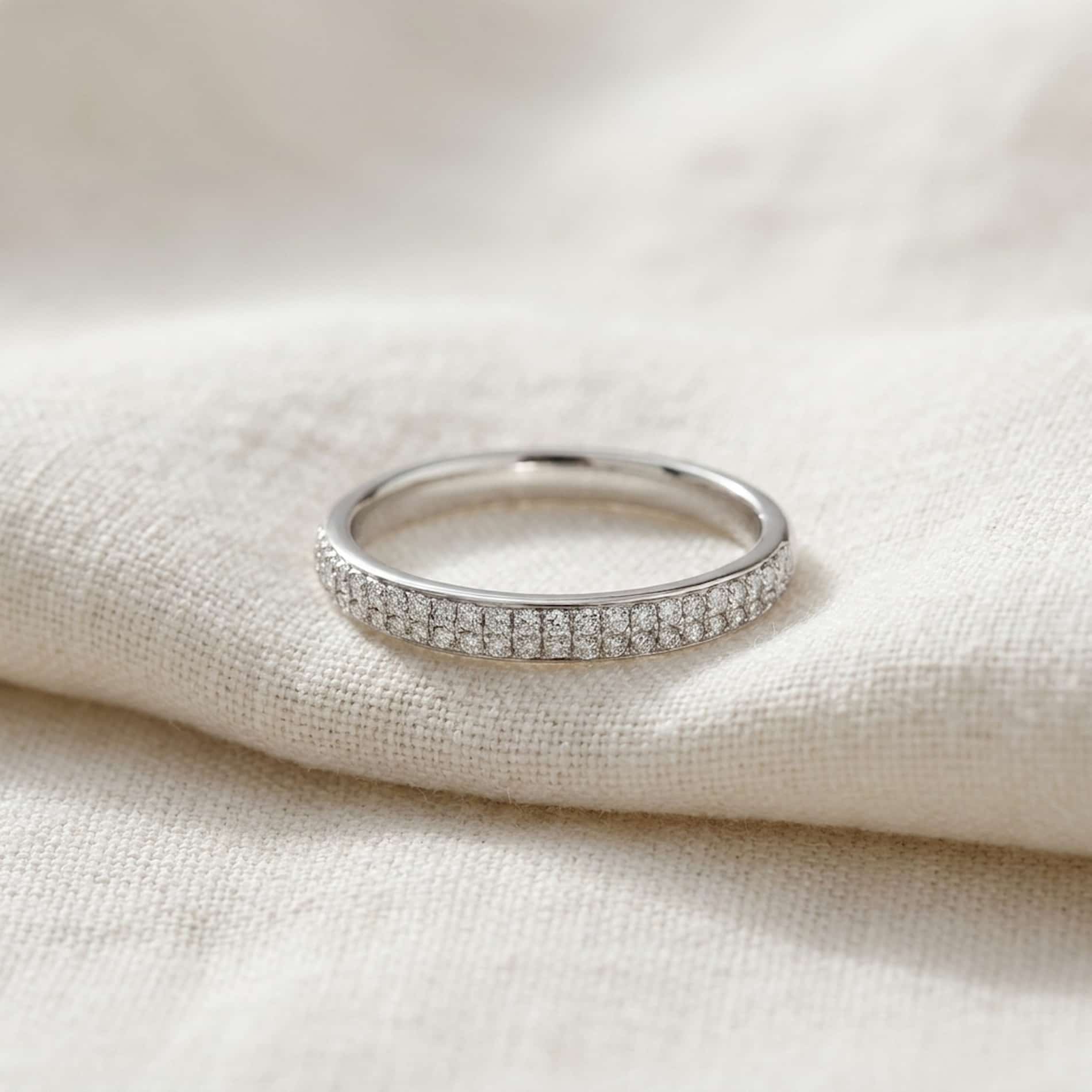Sophie alliancering i 18 karat hvidguld med 0,25 carat hvide diamanter på lyst stof