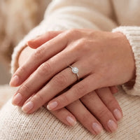 Kvinde bærer Alma ring i hvidguld med diamantroset på fingeren