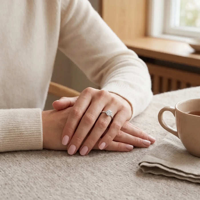 Hænder ved kaffekop med Alma ring i hvidguld med diamanter