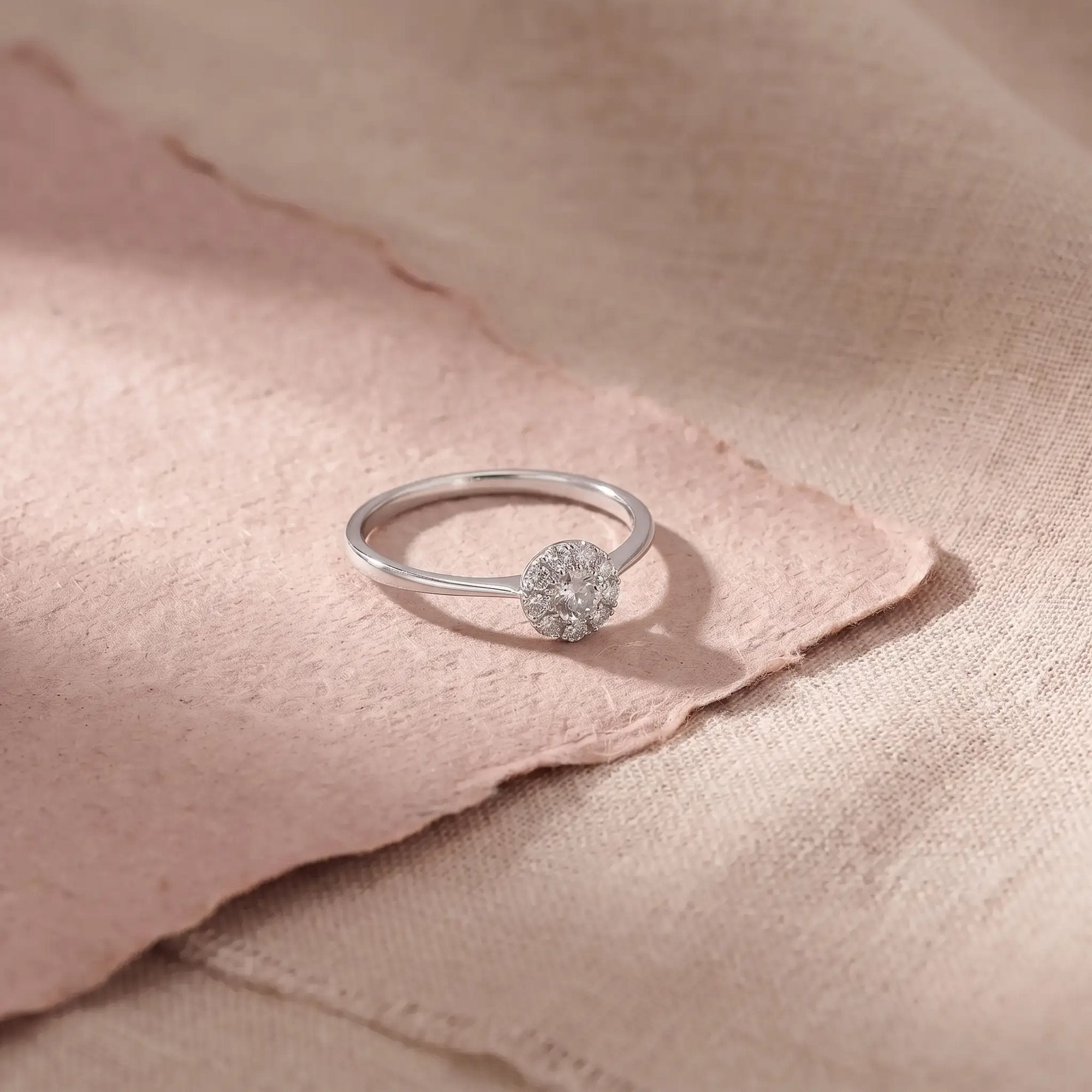 Alma ring i hvidguld med 0,24 carat diamanter på lyserødt papir