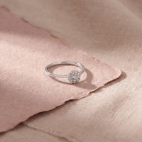Alma ring i hvidguld med 0,24 carat diamanter på lyserødt papir
