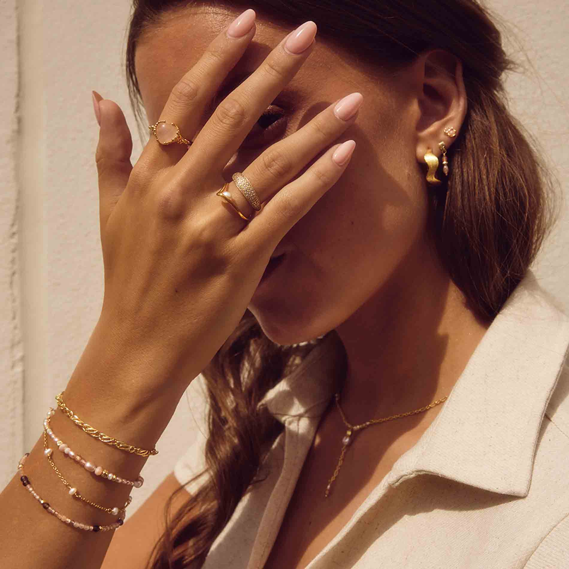 Aqua Dulce Liora armbånd i forgyldt sølv med rosa ferskvandsperler og zirkonia, båret på håndleddet