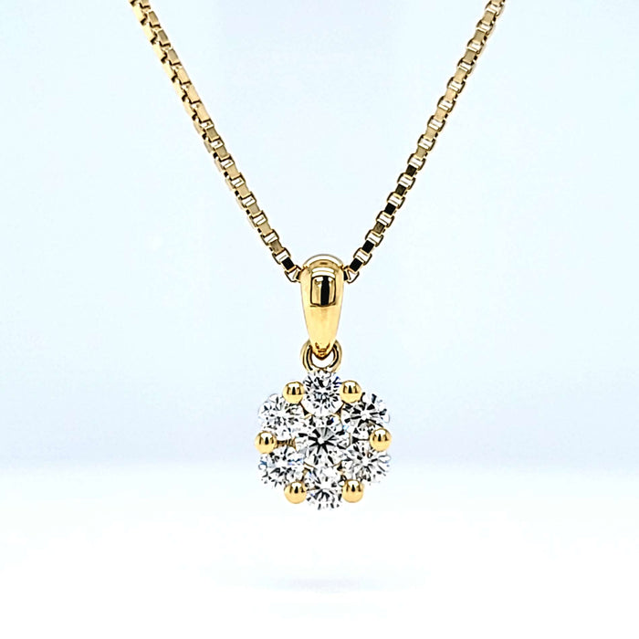 Vedhæng i guld med 7 diamanter fattet i et blomstermotiv, set på kæde