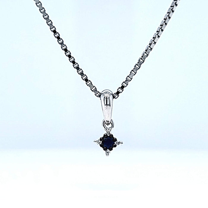Vedhæng i hvidguld med en blå safir og fire hvide diamanter, set forfra på kæde