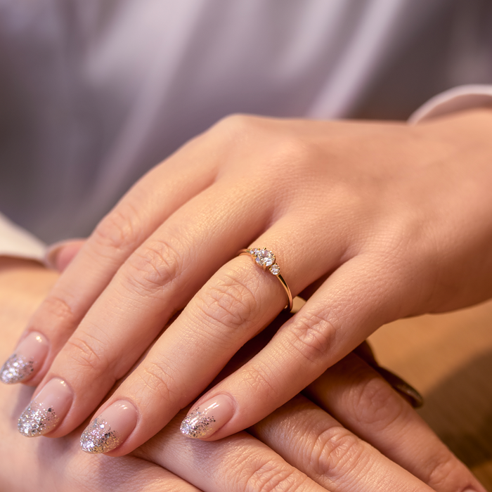 Elegant forgyldt ring med centersten og to sidesten båret på hånd
