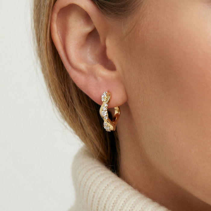 Ellera Waves Altro Creolo øreringe i forgyldt med zirkonia sten vist på øre