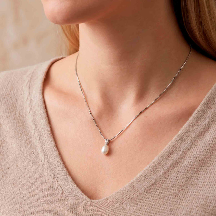 Ellie perlevedhæng i 14 karat hvidguld med ferskvandsperle og diamanter båret på halsen