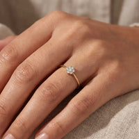 Fleur ring i 18 karat guld med syv brillantslebne diamanter, vist på en hånd.