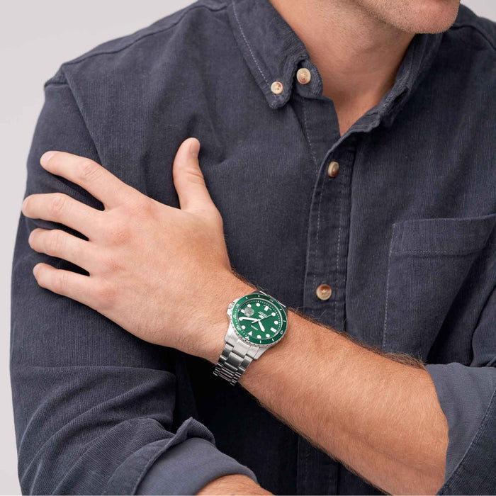 Stålur fra Fossil med grøn skive og krans, på model