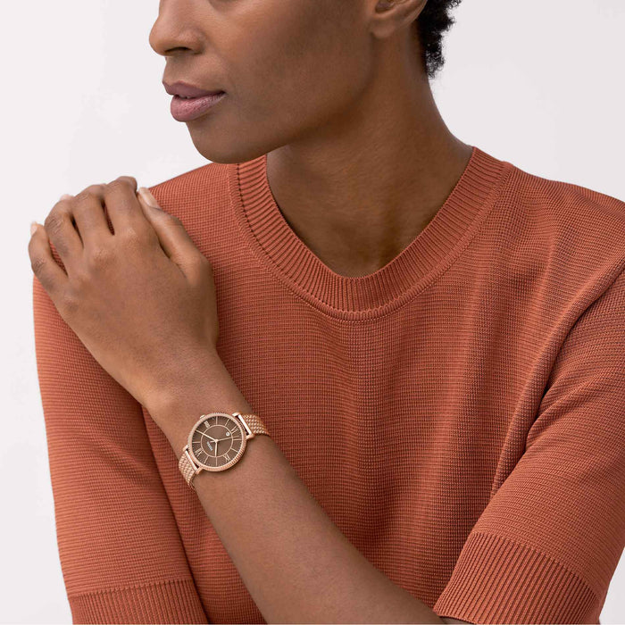 Rosegold ur med brun skive fra Fossil, set på håndled