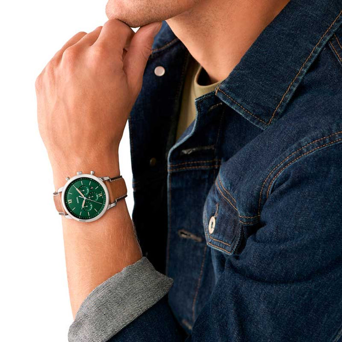 Fossil Neutra herreur i stål med brun læderrem og grøn skive. Uret ses på håndledet af en mand.