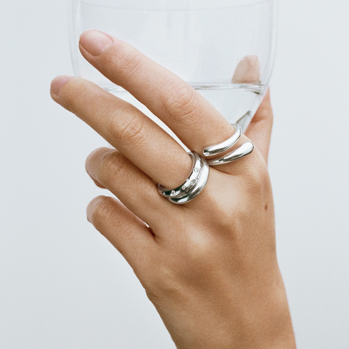 Georg Jensen Mercy ring i 925 sterlingsølv båret på hånd sammen med andre ringe