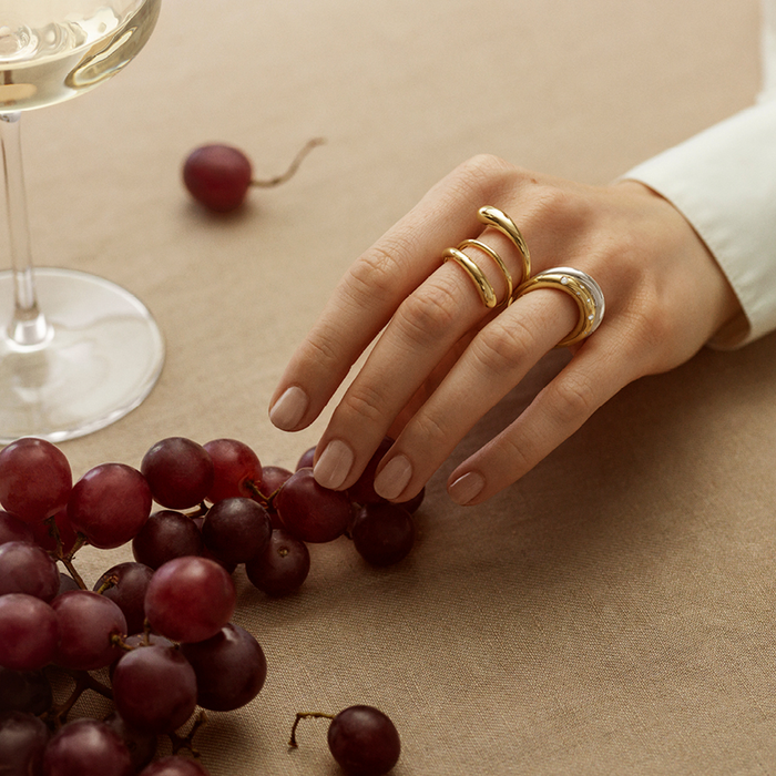 Georg Jensen Mercy Twist ring i 18 karat guld båret på hånd sammen med andre ringe
