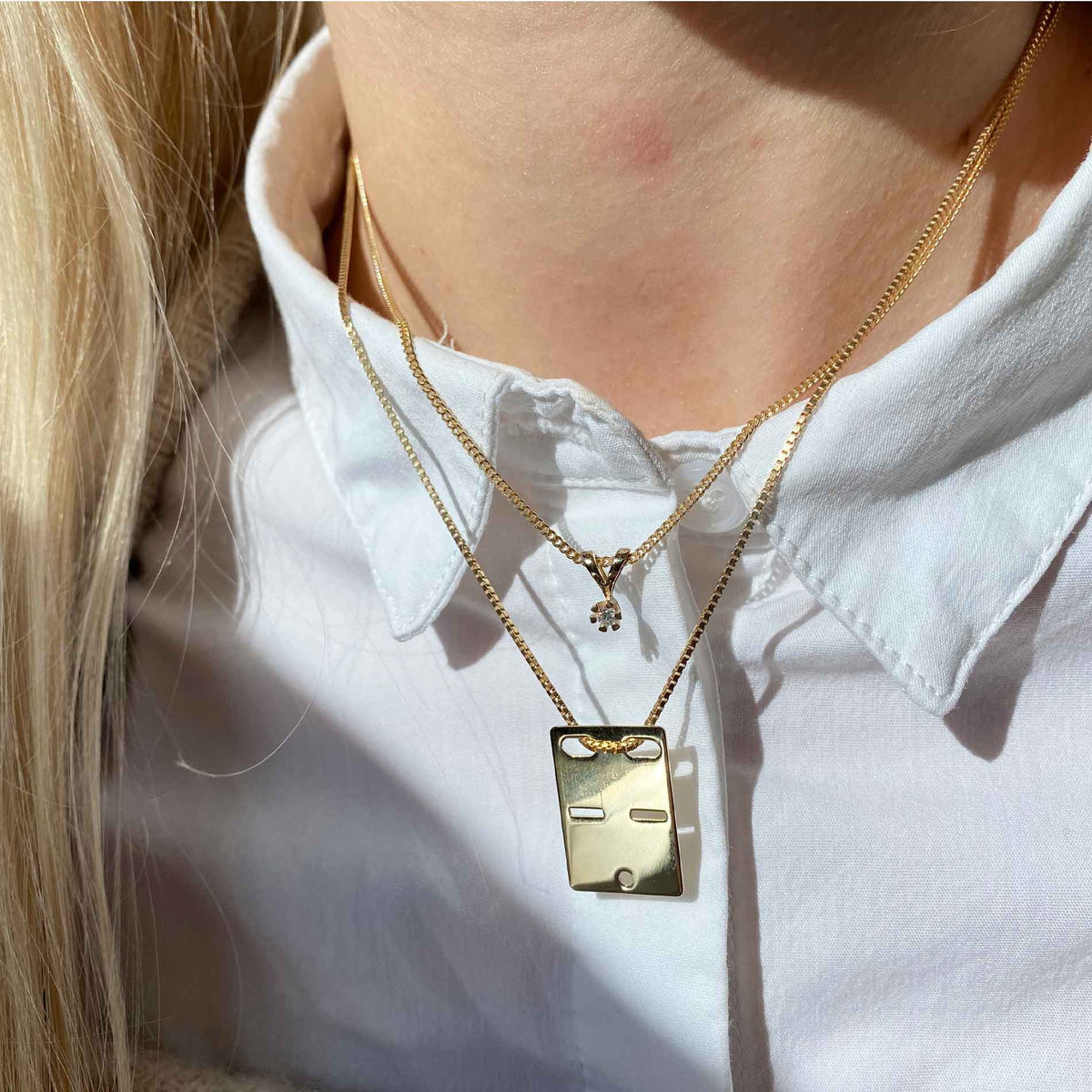 Solitaire diamantvedhæng i guld, på model med anden halskæde