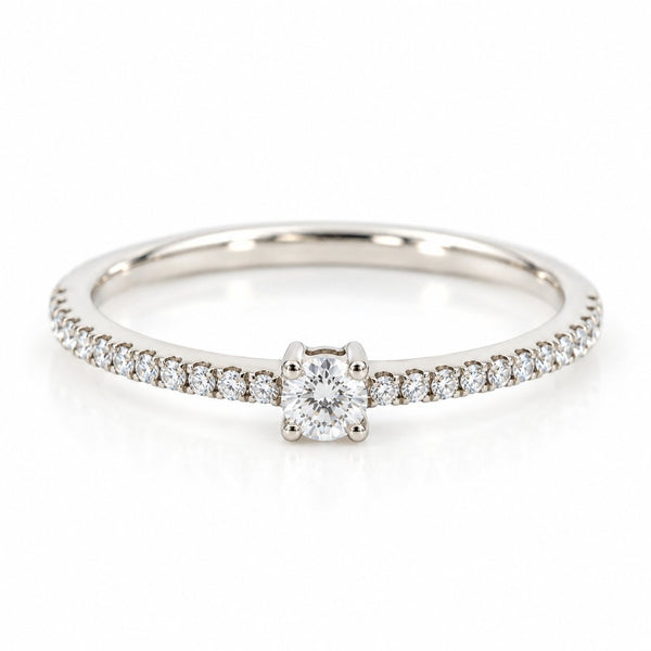 Infinity ring i 18 karat hvidguld med solitærdiamant og diamanter i skinnen, i alt 0,21 carat, hvid baggrund