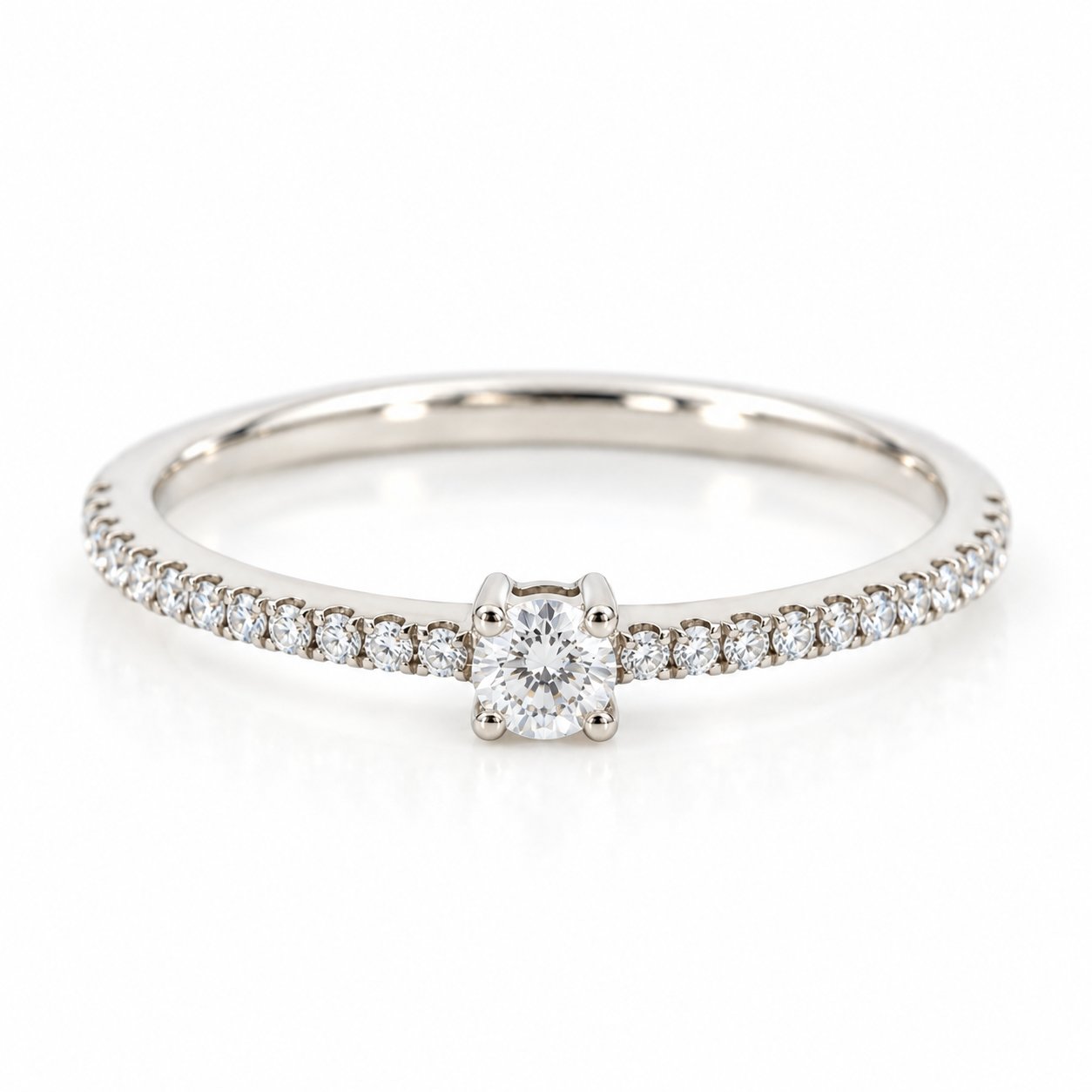 Infinity ring i 18 karat hvidguld med solitærdiamant og diamanter i skinnen, i alt 0,21 carat, hvid baggrund