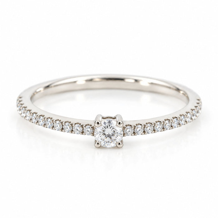 Infinity ring i 18 karat hvidguld med solitærdiamant og diamanter i skinnen, i alt 0,21 carat, hvid baggrund