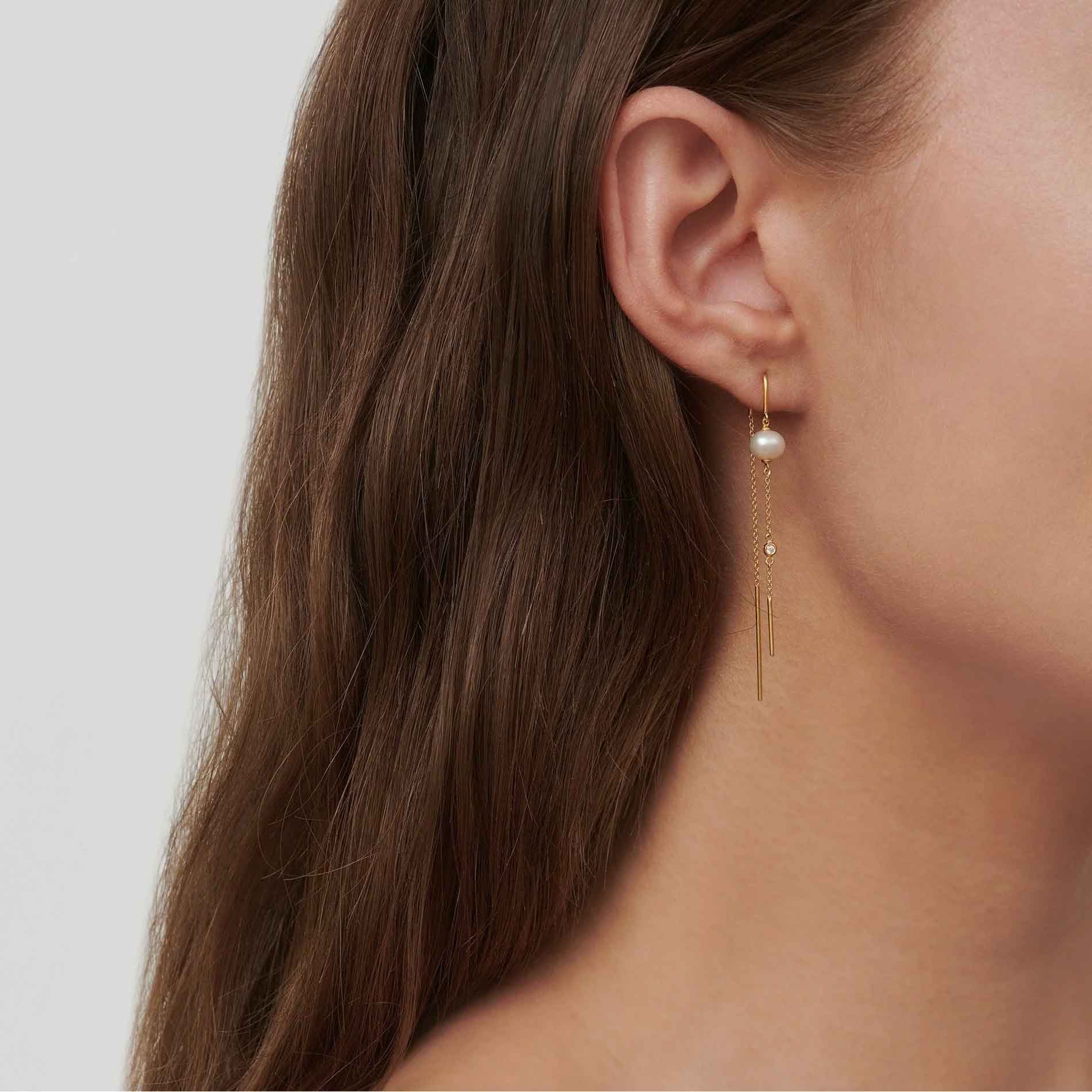 Forgyldte øreringe med hvide perler og klare zirkonia fra Julie Sandlau på model
