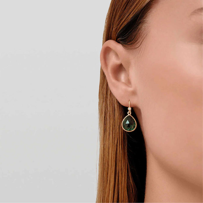 Forgyldte øreringe med grønne krystaller fra Julie Sandlau på model