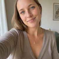 Kvinde bærer Livets Træ halskæde i 8 karat guld. Det elegante vedhæng med fine grene og blade symboliserer vækst, kærlighed og livets skønhed