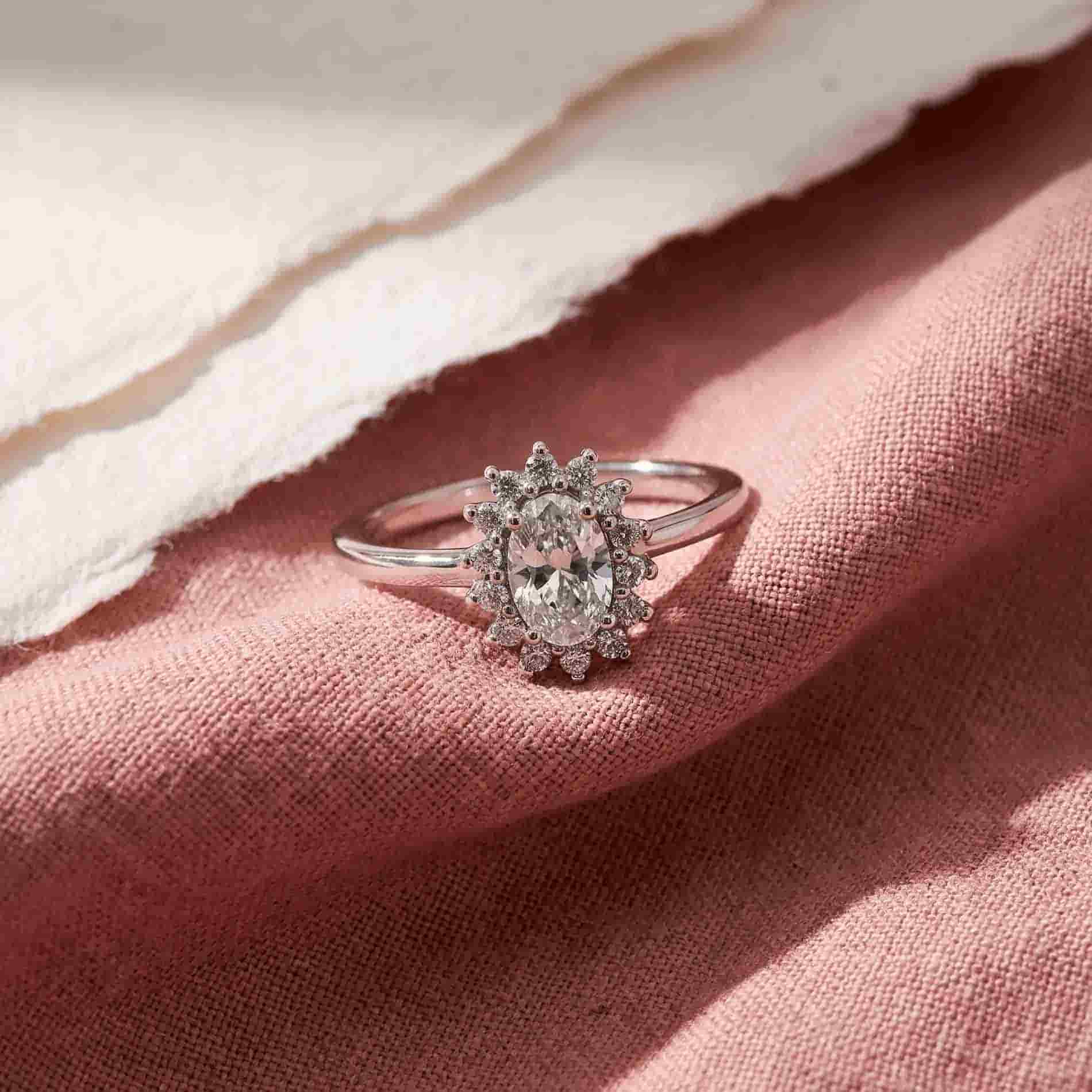 Luda ring i sølv med oval klar zirkonia og mindre klare zirkonia sten på rosa tekstil