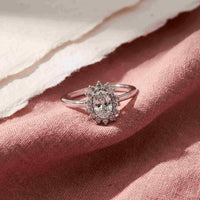 Luda ring i sølv med oval klar zirkonia og mindre klare zirkonia sten på rosa tekstil