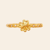Maanesten Clover ring i forgyldt sølv set oppefra med dekorativt firkløvermotiv og små hvide zirkonia.